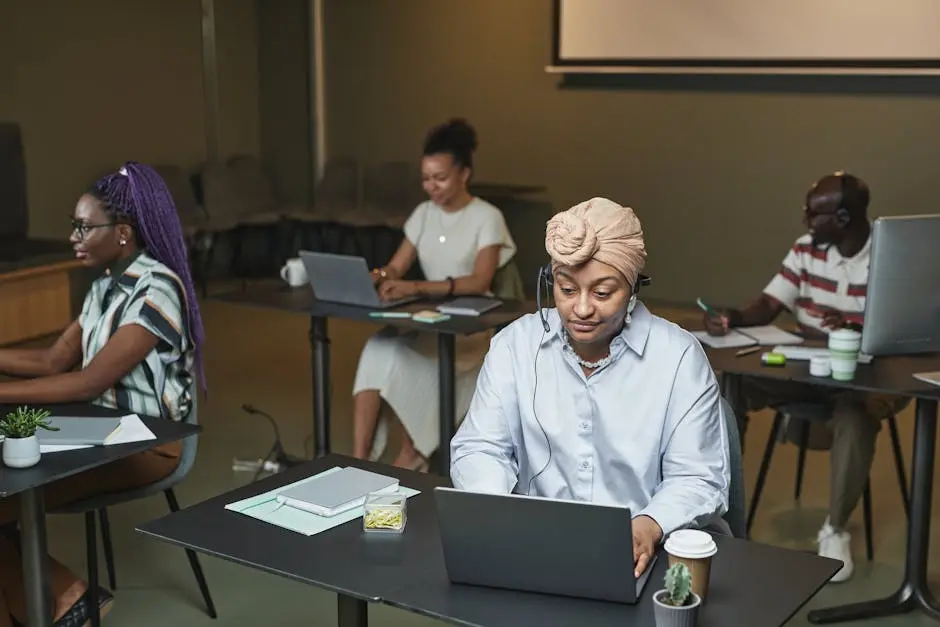 A diverse group of professionals working at laptops in a modern office setting.