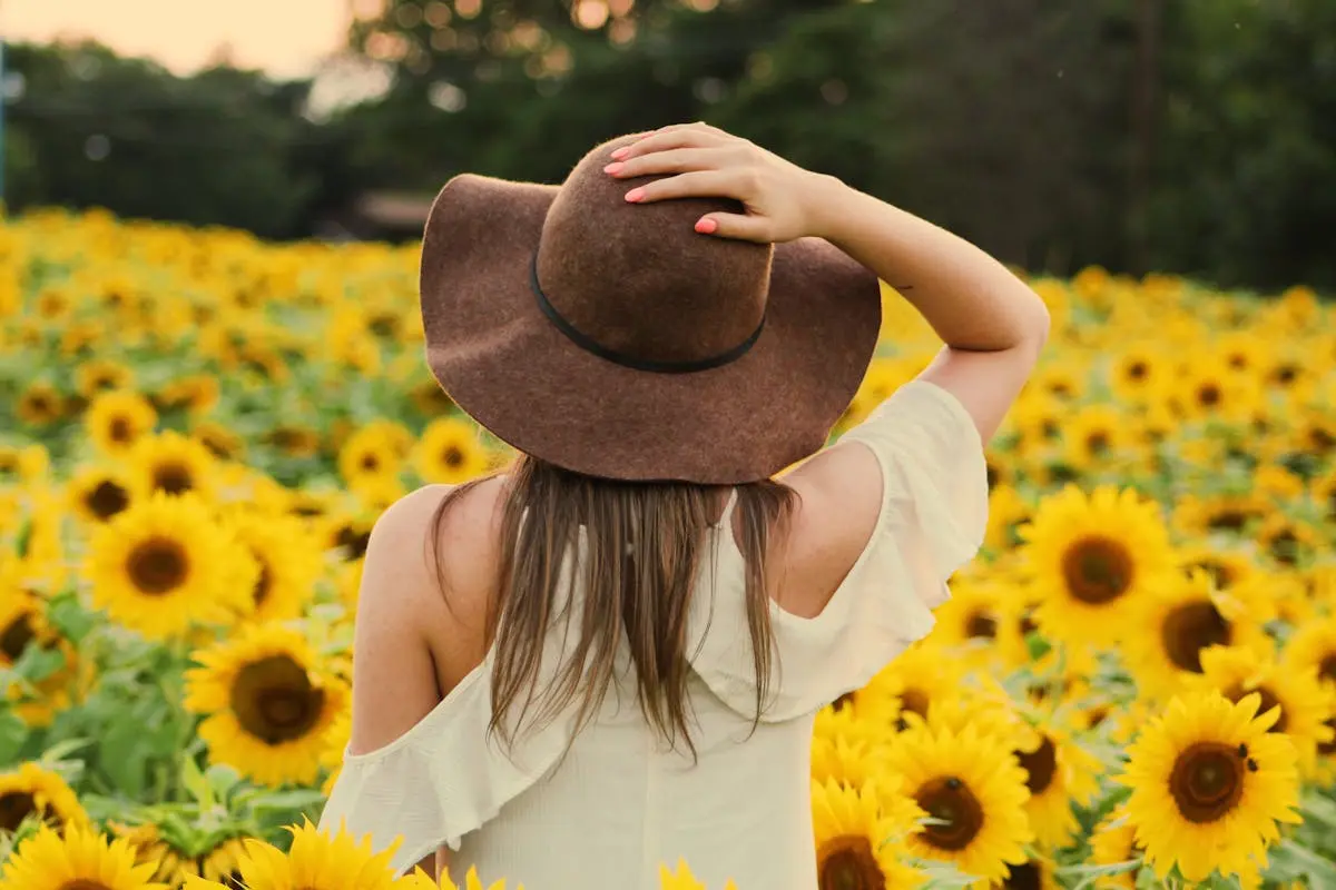 A woman enjoying the beauty of a sunflower field in summer’s golden glow.