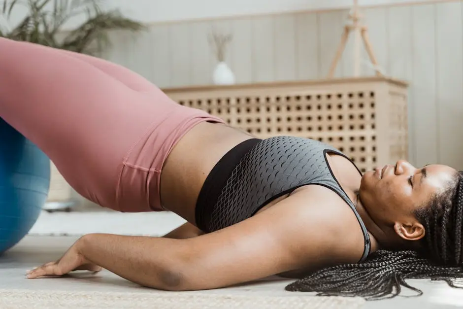 Young woman in activewear doing home workout with a fitness ball. Emphasizes body positivity and wellness.