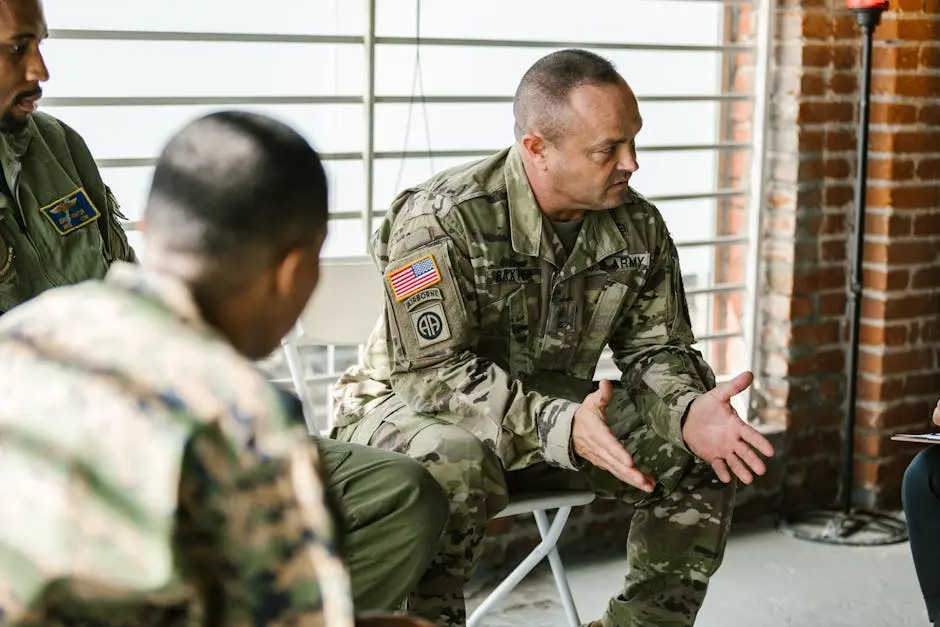 Military veterans engaging in a supportive group therapy session indoors.
