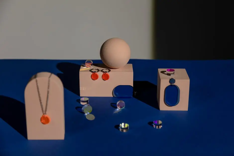 A modern display featuring geometric jewelry on a vibrant blue surface with artistic shadows.