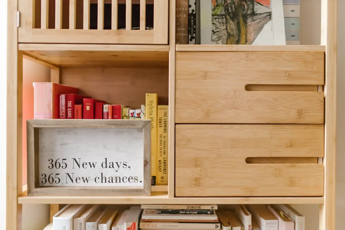 Wooden bookshelf with books and a motivational quote sign: ‘365 New days, 365 New chances.’