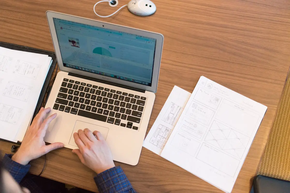 An overhead view of a person working on a laptop thinking about career change
