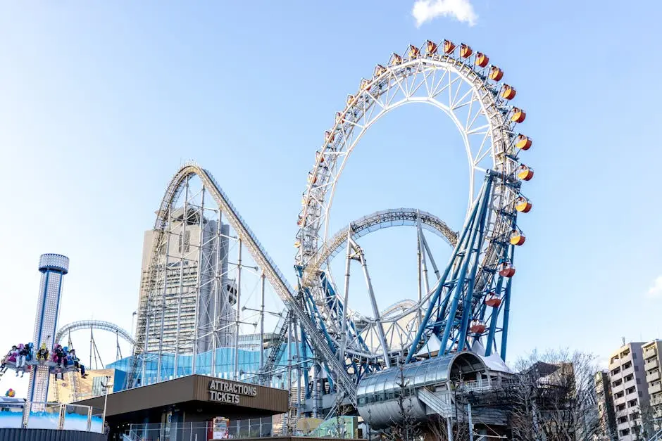 Vibrant Ferris wheel and roller coaster at Tokyo Dome City amusement park during daytime.