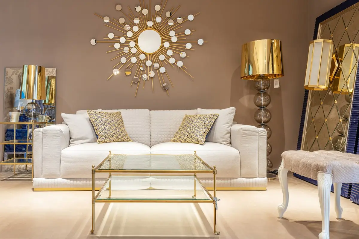 Stylish living room with white sofa, gold decor, and glass table for modern homes.