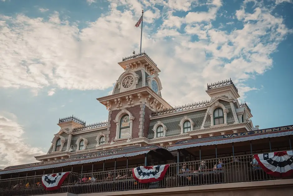 Iconic entrance to Walt Disney World Railroad at Magic Kingdom, Orlando, Florida, with vintage architecture and American flags.