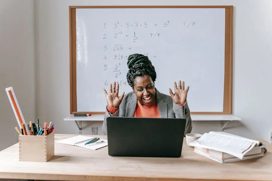 Cheerful African American female teaching online lesson with netbook in modern classroom