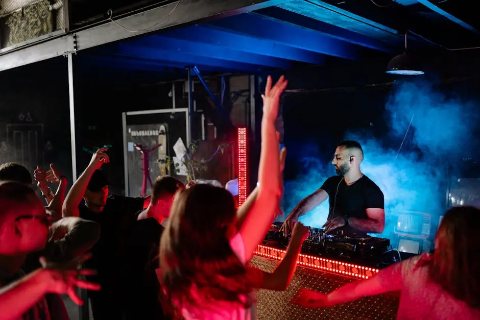Exciting nightclub atmosphere with a DJ and enthusiastic crowd enjoying the music.