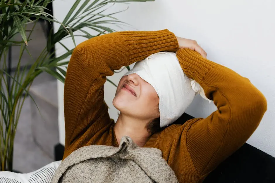 Woman in warm sweater resting with head bandage, showcasing cozy recovery indoors.