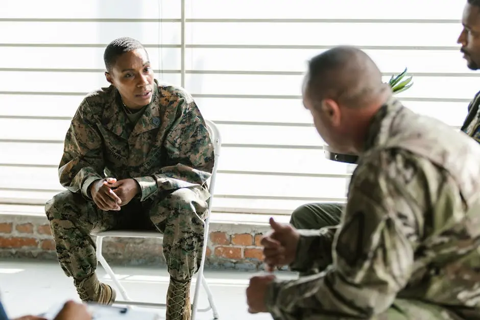 Military veterans engage in a supportive group therapy session indoors.