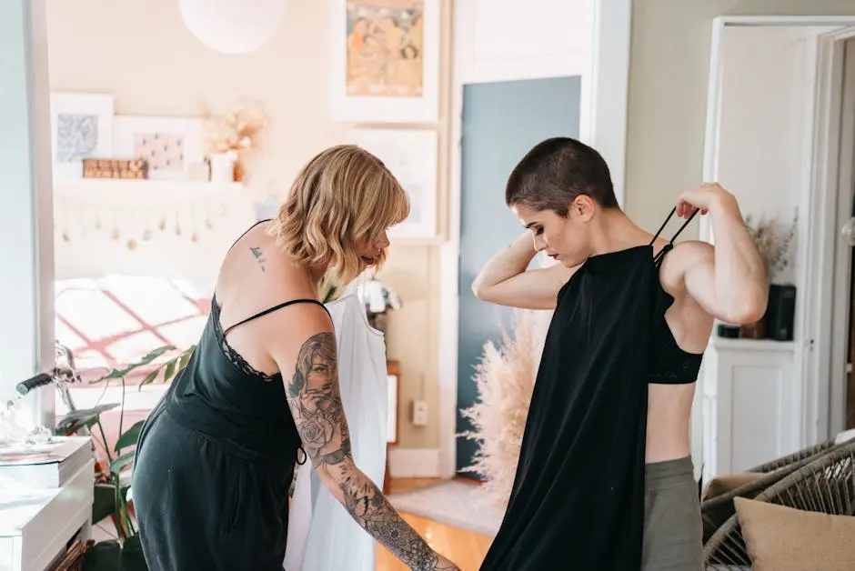 Two women deciding on outfits indoors, showcasing personal style and friendship.