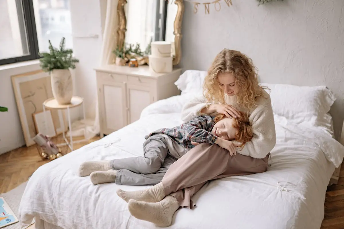 Mother and son sharing a tender moment in a beautifully decorated bedroom setting.