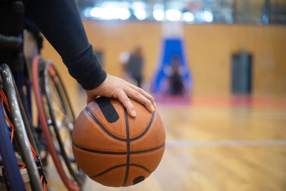 Wheelchair basketball player gripping ball on indoor court, emphasizing inclusivity and sportsmanship.