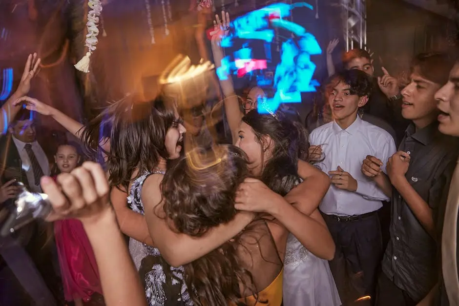 Teenagers joyfully celebrate at a lively indoor party with music and dancing.