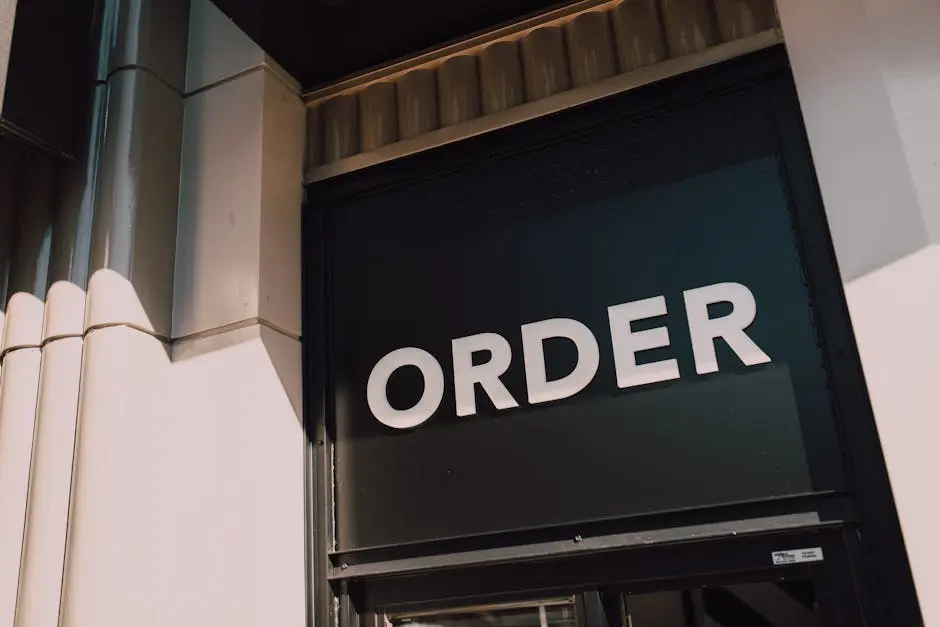 A sunlit view of a modern storefront with prominent ‘Order’ signage, highlighting a streamlined design.