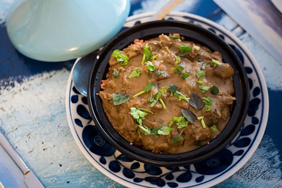 A savory Moroccan tagine garnished with fresh herbs, served in a traditional dish.