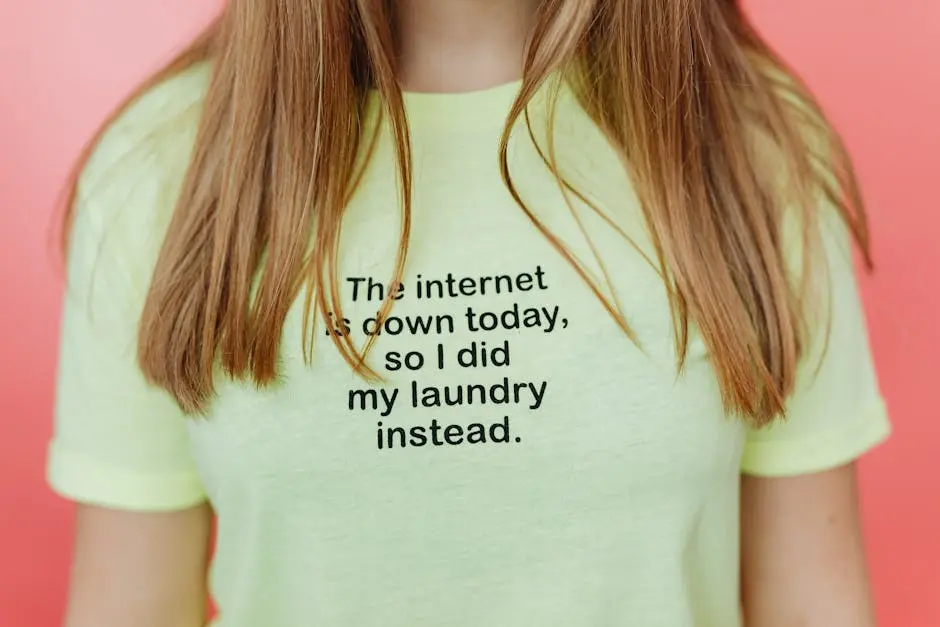 Young woman in a witty t-shirt against a pink background, blending casual style with humor.
