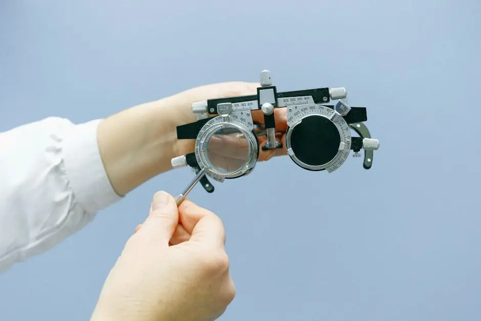 Hands adjusting an optometry trial lens set with a blue background. Ideal for vision and health topics.