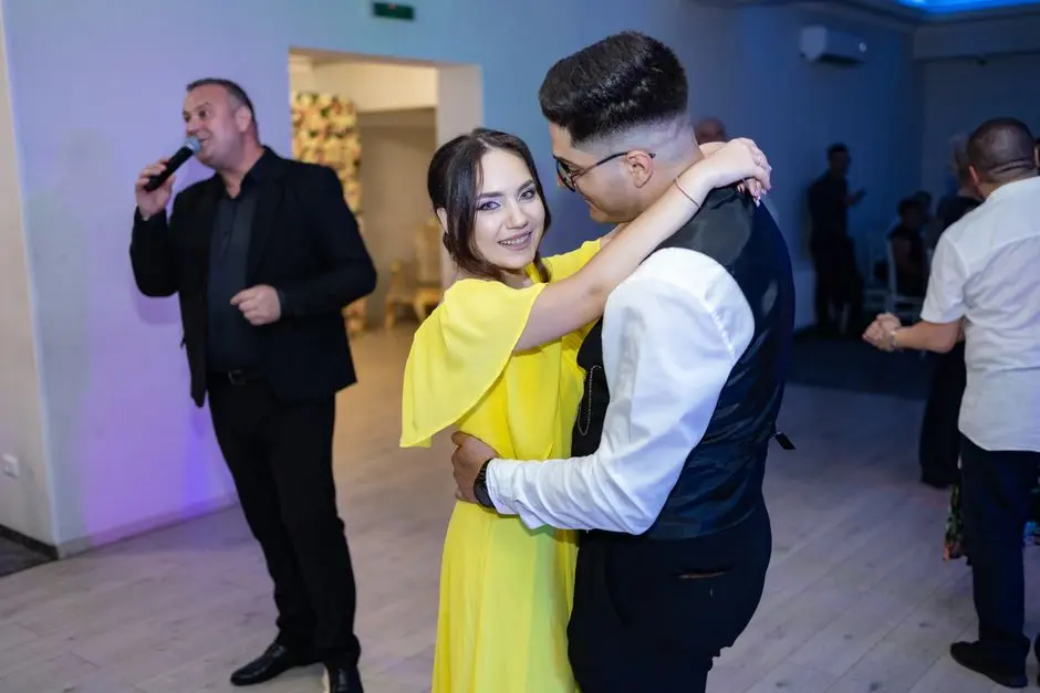 A joyful couple dancing at an indoor wedding with live entertainment.