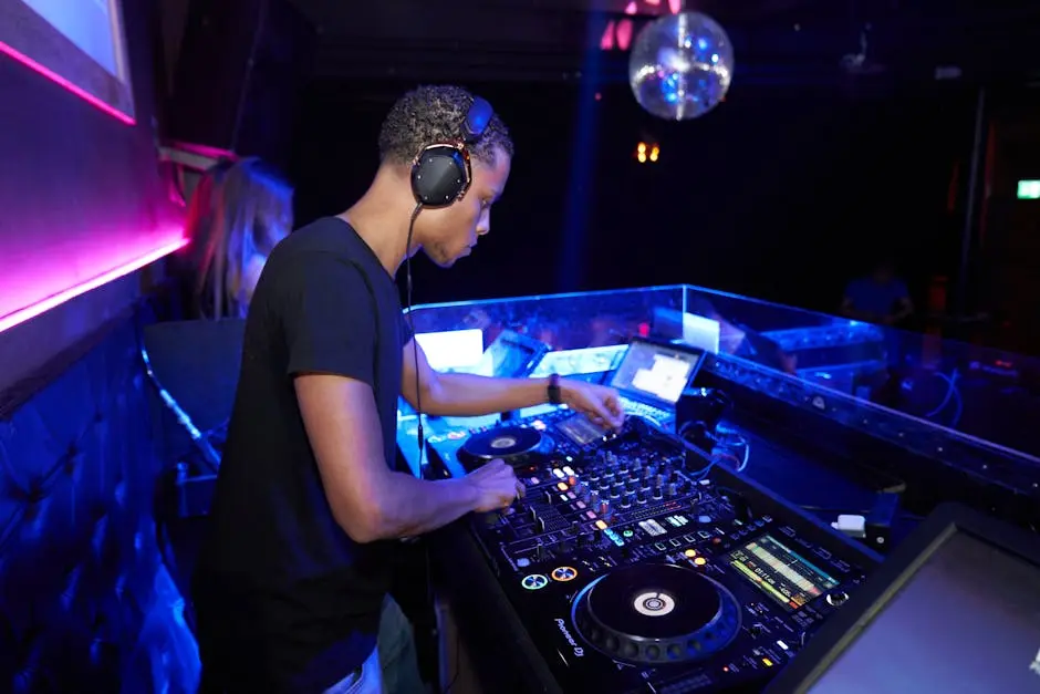 DJ mixes music at a vibrant nightclub with disco lights and an enthusiastic crowd.