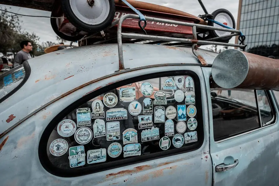 Close-up of vintage car window covered in various travel stickers, showcasing retro vibes.