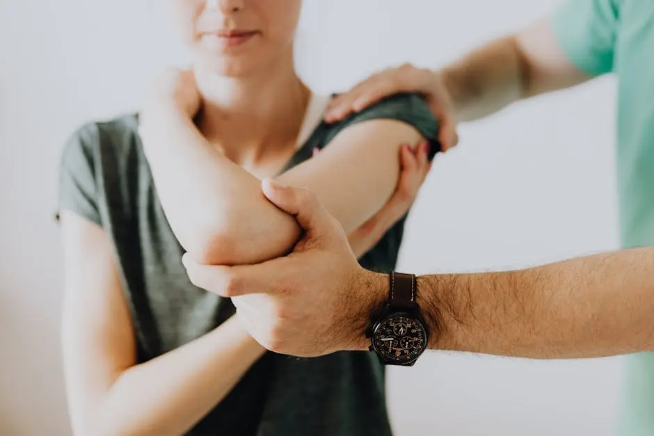 A chiropractor adjusting a patient’s arm in a clinic setting, focusing on health and care.