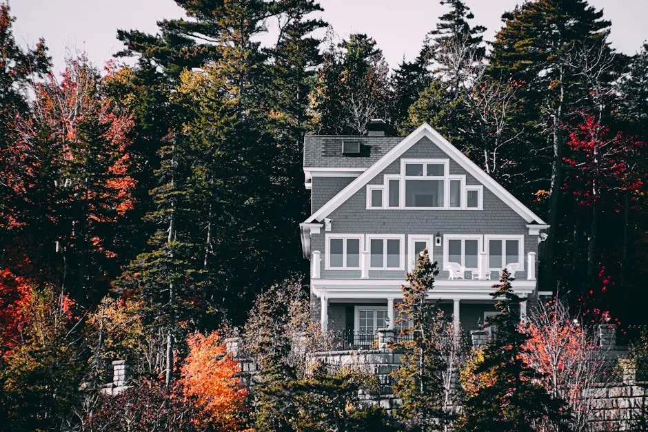Elegant family home set against a vibrant autumn forest backdrop.