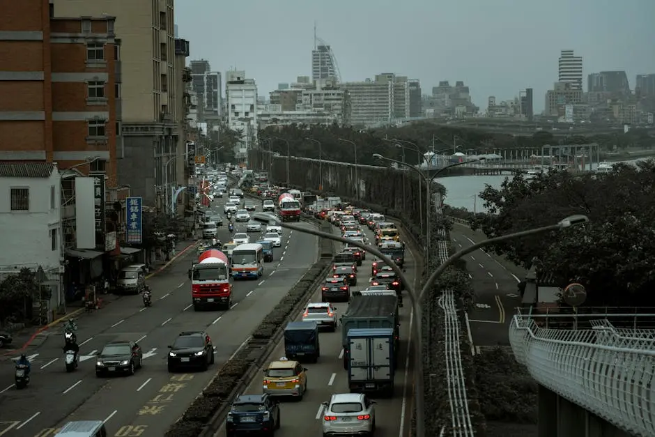 A bustling city street filled with cars and trucks in an urban traffic jam during the day.