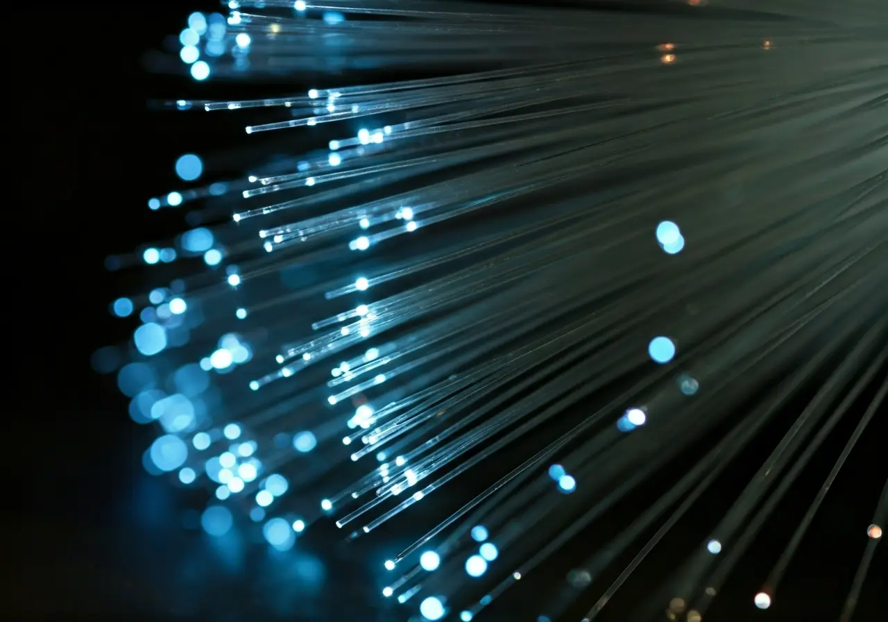 A close-up of glowing fiber optic cables in darkness. 35mm stock photo