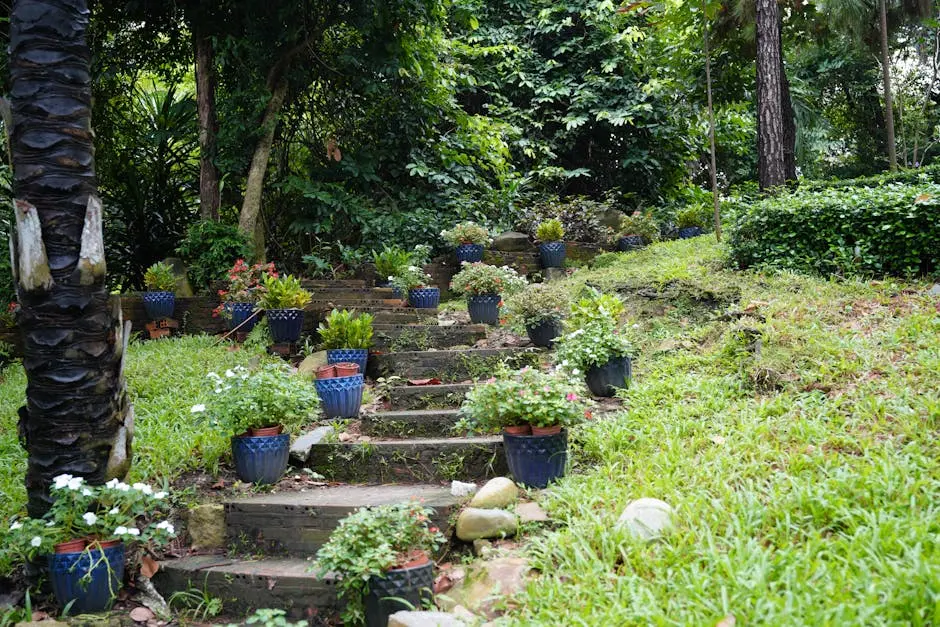 A serene garden staircase adorned with vibrant plants in blue pots, surrounded by lush greenery.