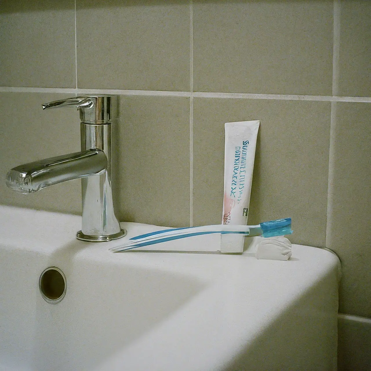 A toothbrush and sensitive toothpaste on a bathroom counter. 35mm stock photo