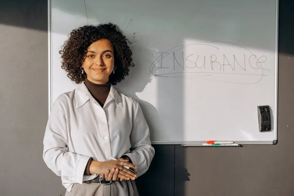 Smiling woman with curly hair standing by a whiteboard with ‘insurance’ written on it, conveying professionalism.