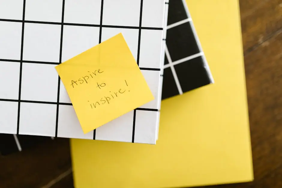 Motivational quote ‘Aspire to inspire’ on a sticky note placed on books. Minimal and inspirational visual.