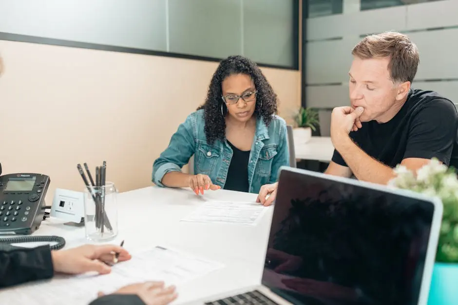 A couple discussing legal documents inside an office setting with an advisor.