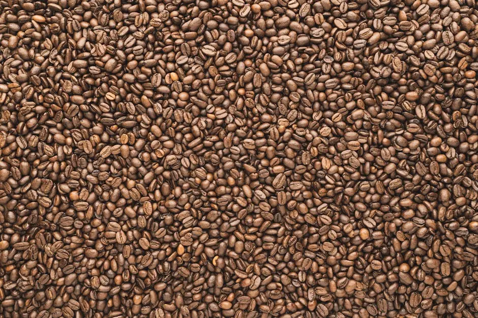A close-up view of a textured surface full of roasted coffee beans, perfect for food and beverage themes.