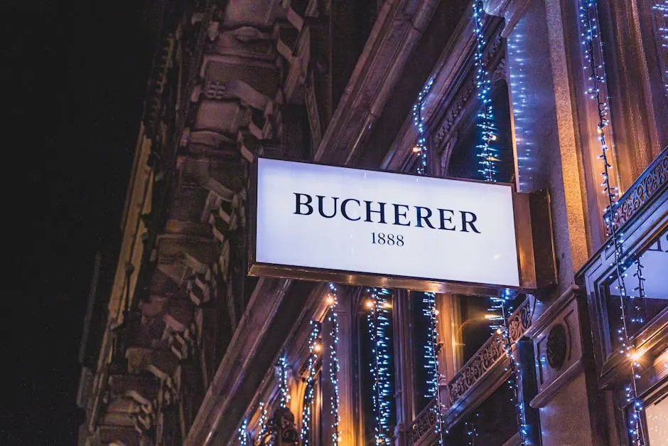 Nighttime view of Bucherer store sign with festive Christmas string lights in a city setting.