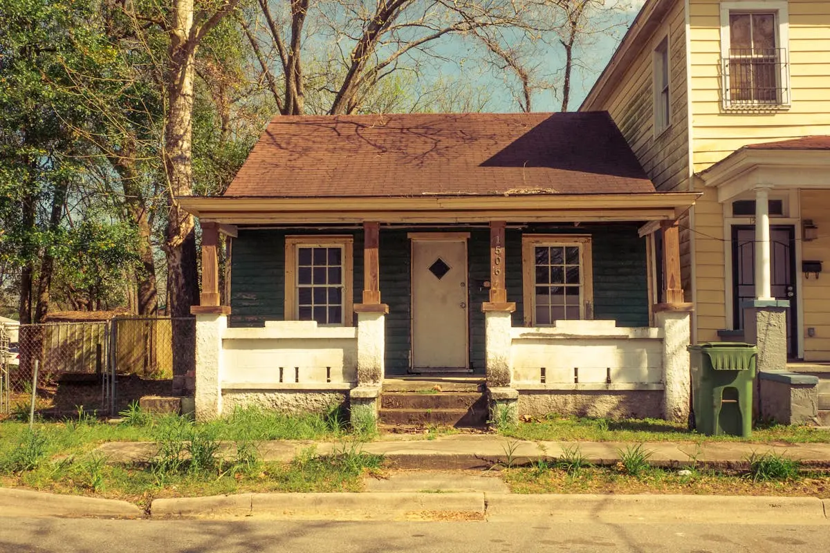 Charming vintage house with porch in a sunny suburban neighborhood.