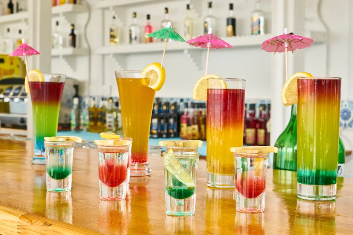 Vibrant cocktails with lemon slices on a bar counter, perfect for a summer vibe.