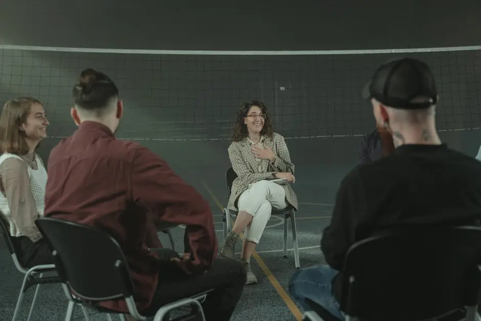 A diverse group of adults participate in a support group meeting indoors.