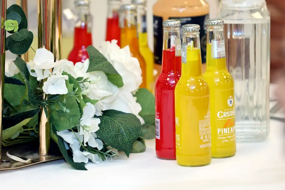 Colorful cocktail bottles with a white floral arrangement on a table setting.