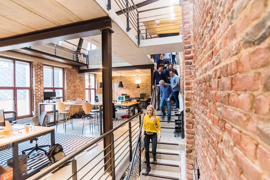 Open-concept office with brick walls, multi-level layout, and team members working together.