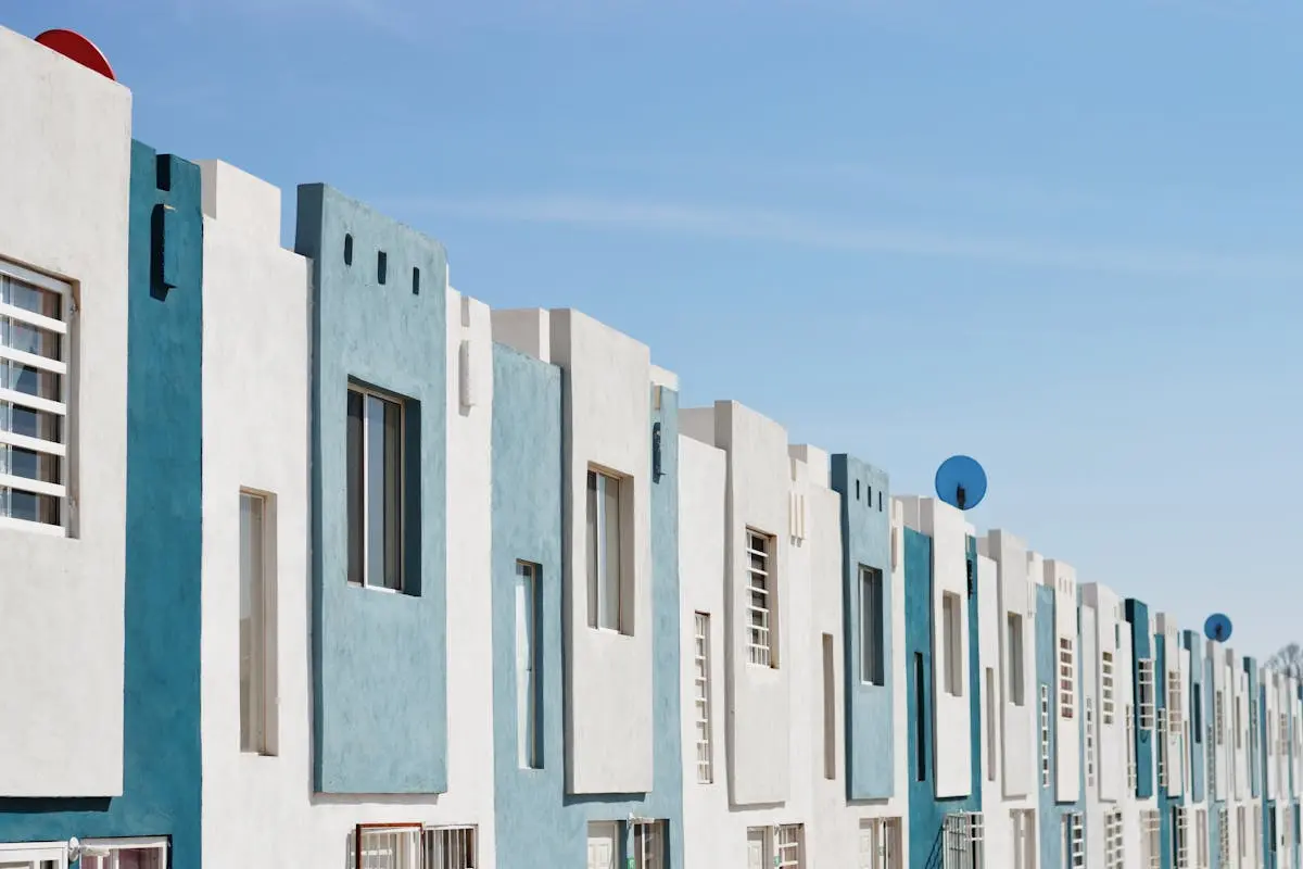 Geometric blue and white facade of a modern apartment building under a clear sky.