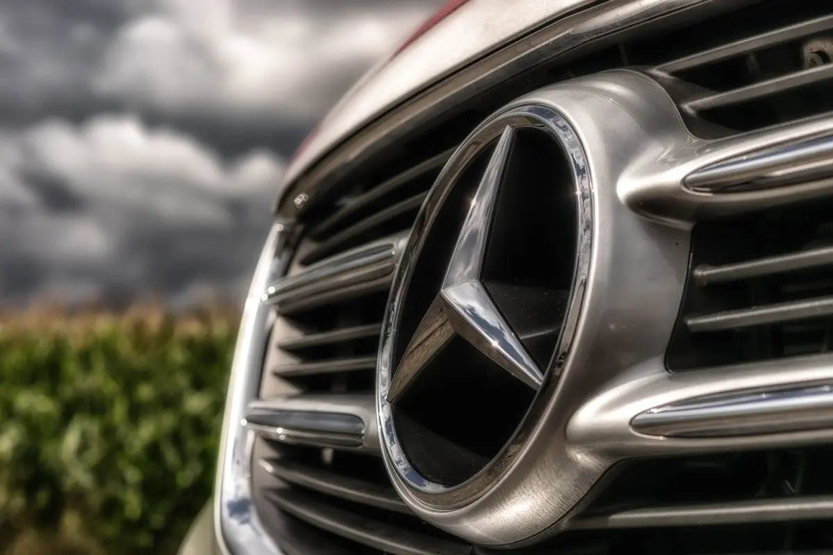 A striking close-up of a shiny Mercedes-Benz car emblem and grille, showcasing luxury.