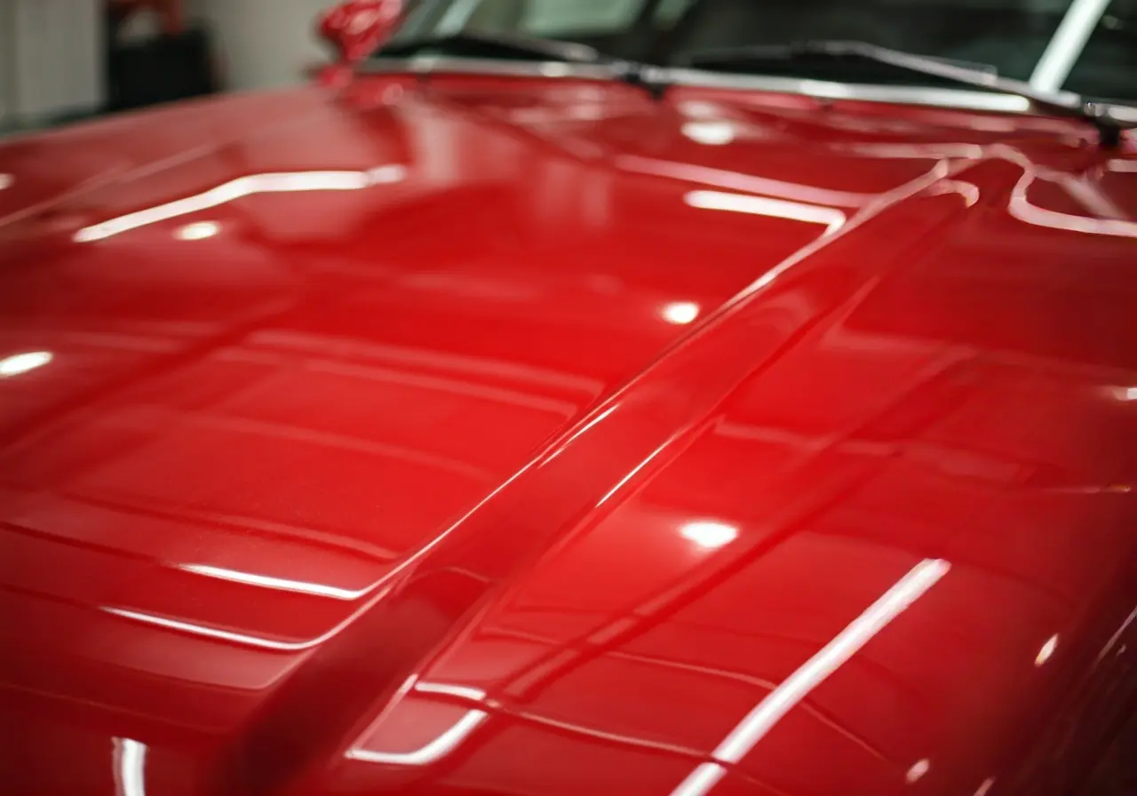 A close-up of glossy red car hood after waxing. 35mm stock photo