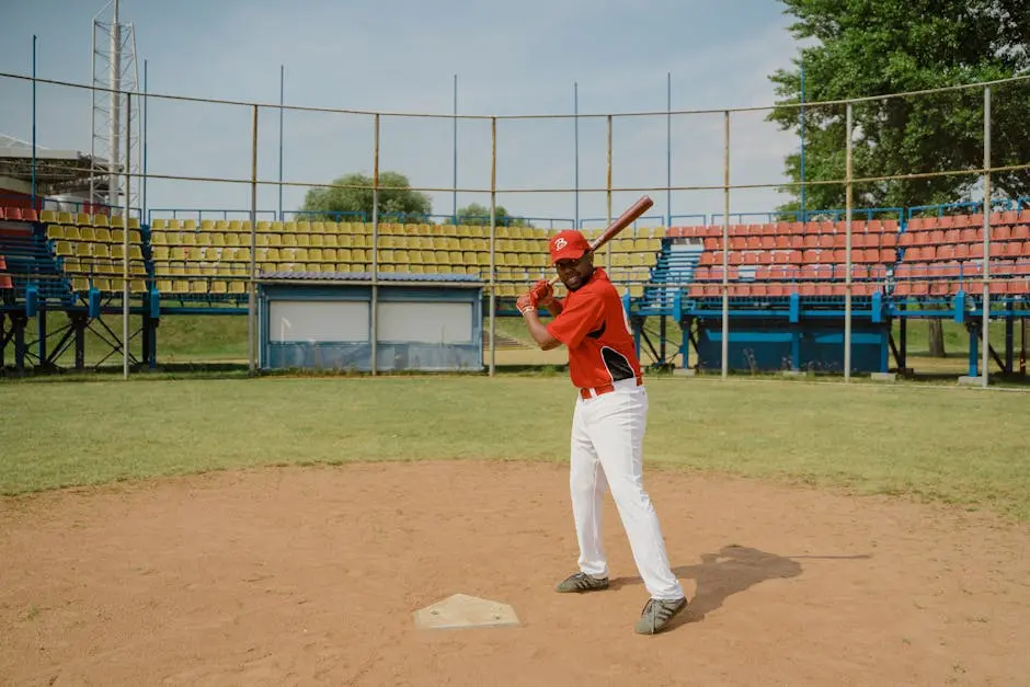 African American baseball player poised to bat at an outdoor field with vibrant seating.
