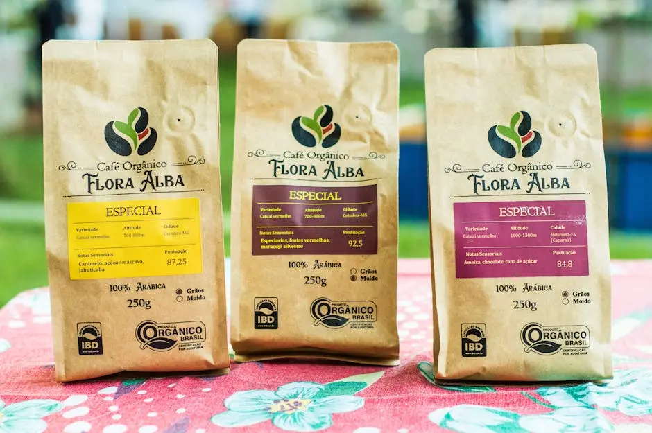Close-up of organic coffee bags, Flora Alba brand, displayed on a table at an outdoor market.