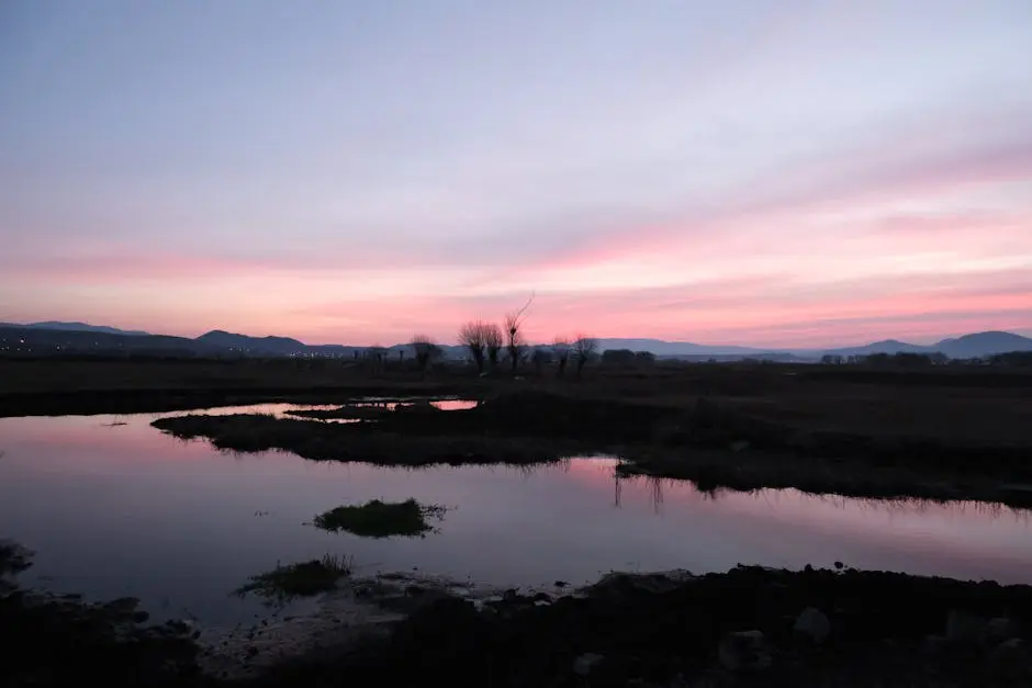 Scenic view of a tranquil twilight landscape with water reflections and pastel skies.
