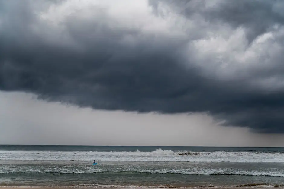 Dark storm clouds hover over waves at Ahangama Beach, Sri Lanka, creating a dramatic seascape.