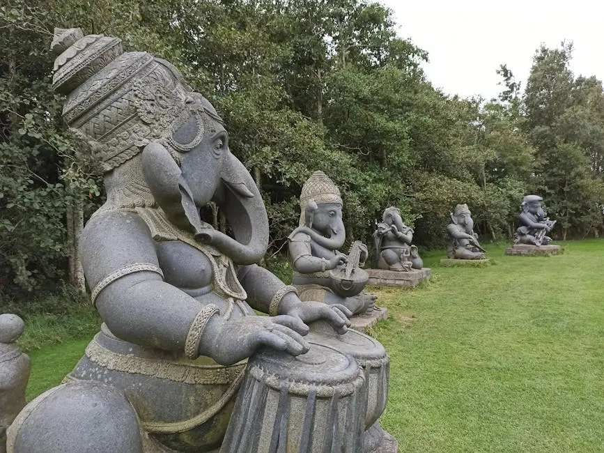 Stone statues of Ganesha playing musical instruments in an Irish garden.
