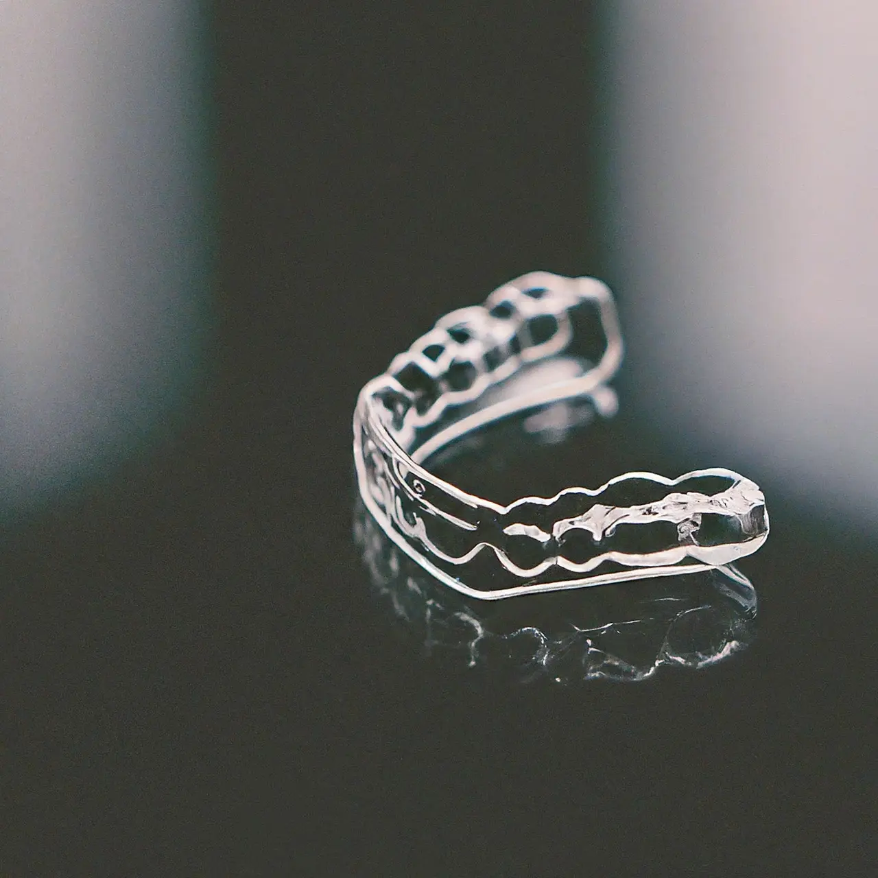 A dental night guard on a reflective surface. 35mm stock photo
